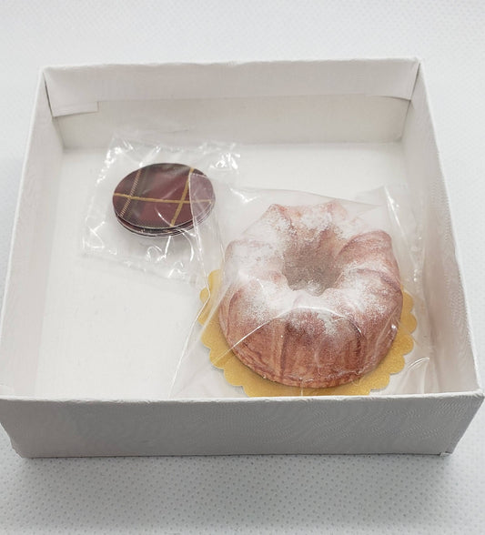 Chef Gina's miniature bundt cake doll food with powdered sugar and a chocolate cookie in a white box