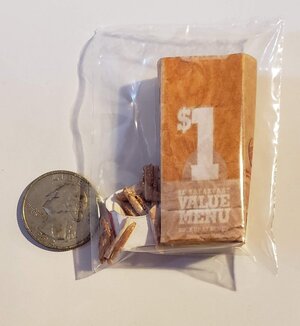 Miniature Burger King fries in a packaging with a quarter for size comparison