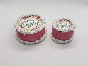 Two miniature Easter cakes for dolls with vibrant icing and floral decorations for festive playtime