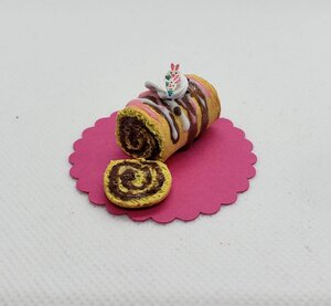 Miniature Easter Swiss roll cake with chocolate filling and decorative icing on a pink base