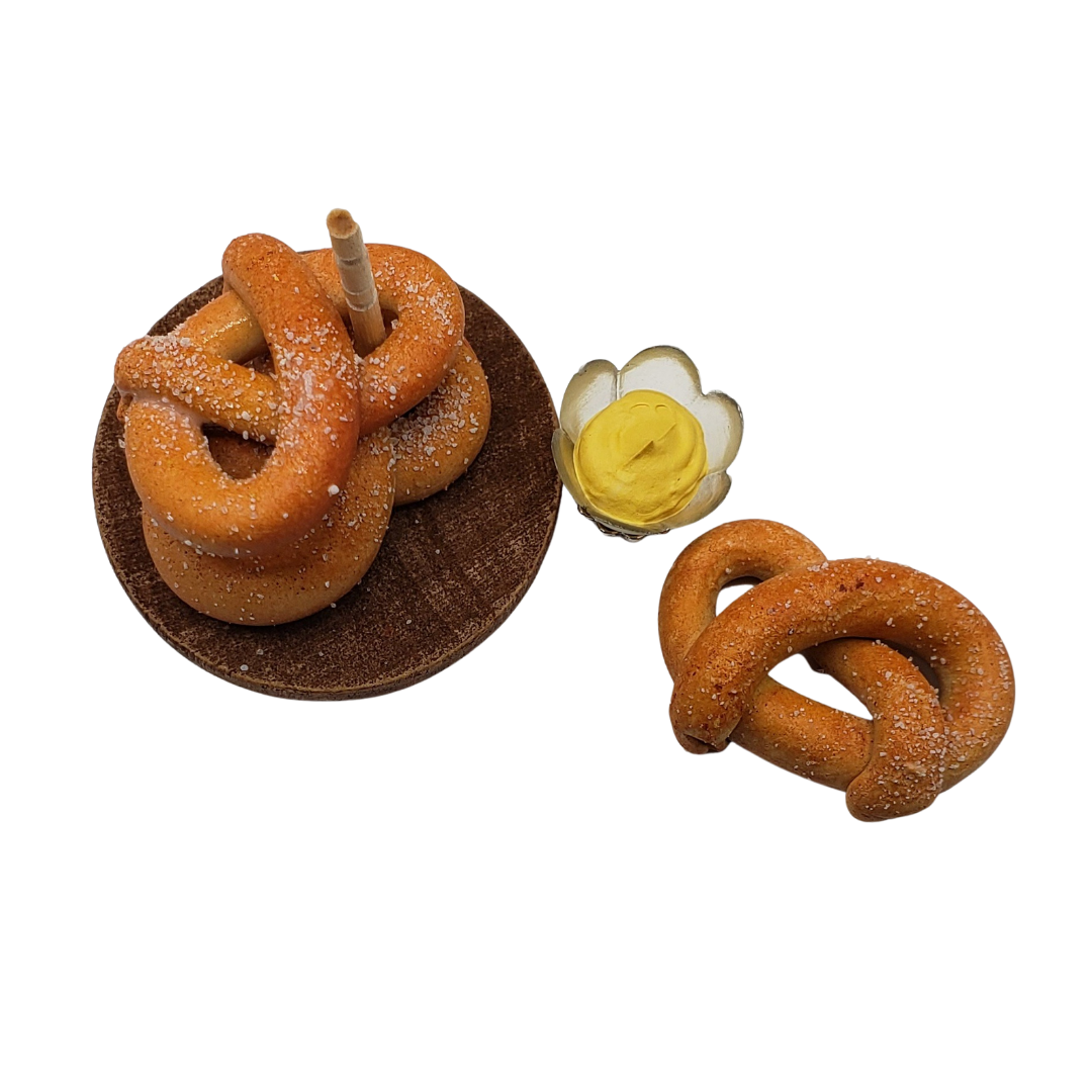 Chef Gina's miniature pretzel tower with a small pretzel and mustard on a wooden plate