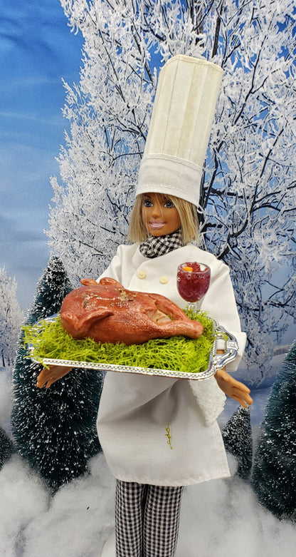 Chef doll holding miniature turkey platter for dolls with roasted turkey and garnish on silver tray